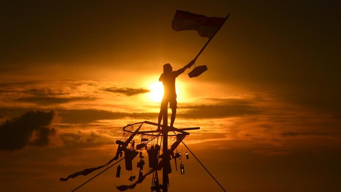 Potret Tradisi Syawalan di Jepara, Panjat Pinang di Laut Warga mengibarkan bendera merah putih saat mengikuti lomba Panjat Pinang di kawasan Pantai Kelurahan Demaan, Jepara, Jawa Tengah, Senin (9/5/2022). Panjat Pinang tersebut untuk memeriahkan tradisi Syawalan atau Lebaran ketupat serta untuk menjalin kebersamaan dan menghibur warga. ANTARA FOTO/Yusuf Nugroho/pras.