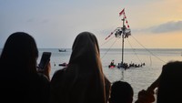 Warga menyaksikan lomba Panjat Pinang di kawasan Pantai Kelurahan Demaan, Jepara, Jawa Tengah, Senin (9/5/2022).