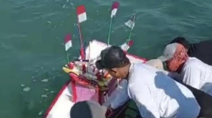 Warga melarung sesaji berupa miniatur kapal yang berisi kepala kambing dan sejumlah hasil bumi ke laut Rembang, Selasa (10/5/2022).