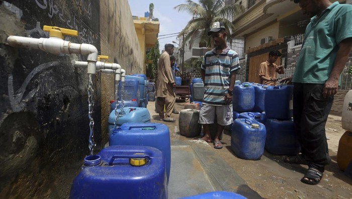 People fill containers at a public water distribution station during a water shortage in Karachi, Pakistan, Monday, May 9, 2022. (AP Photo/Fareed Khan)