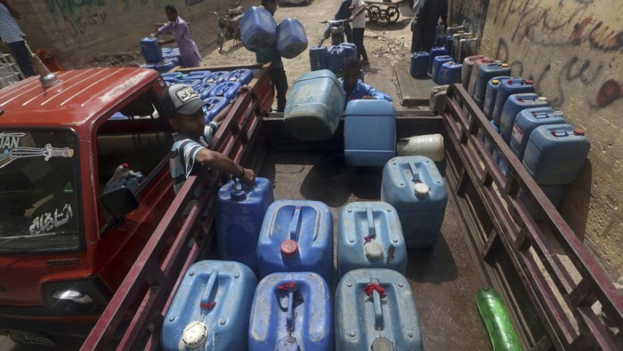 People fill containers at a public water distribution station during a water shortage in Karachi, Pakistan, Monday, May 9, 2022. (AP Photo/Fareed Khan)