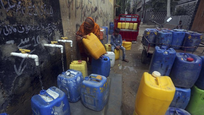 People fill containers at a public water distribution station during a water shortage in Karachi, Pakistan, Monday, May 9, 2022. (AP Photo/Fareed Khan)