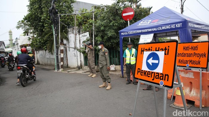 Ada Pekerjaan Sodetan Kali Ciliwung, Lalin di Otista 3 Dialihkan Petugas satpol PP bersama warga menjaga pos pengalihan arus lalu lintas di Jalan Otista 3, Jakarta Timur, Rabu (11/5/2022).