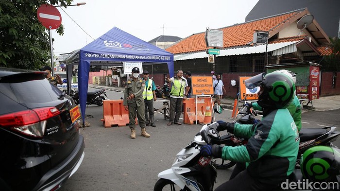 Ada Pekerjaan Sodetan Kali Ciliwung, Lalin di Otista 3 Dialihkan Petugas satpol PP bersama warga menjaga pos pengalihan arus lalu lintas di Jalan Otista 3, Jakarta Timur, Rabu (11/5/2022).