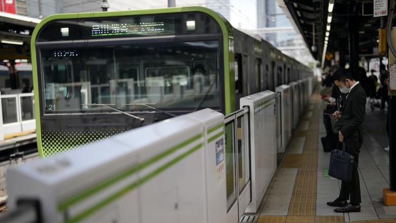 Japan Daily Life A man wearing a protective mask to help curb the spread of the coronavirus stands at a train station platform Tuesday, May 10, 2022, in Tokyo. (AP Photo/Eugene Hoshiko)