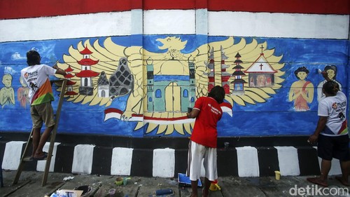 Peserta mengikuti lomba melukis mural di Harapan Jaya, Bekasi, Jawa Barat, Rabu (11/5/2022). Lomba mural bertemakan keberagaman Indonesia merupakan rangkaian dari kegiatan Tentara Manunggal Masuk Desa (TMMD) ke 113 Kodim 0507/Bekasi.