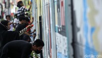 Para peserta membuat mural di dinding yang membentang di kawasan Harapan Jaya, Bekasi, Jawa Barat.