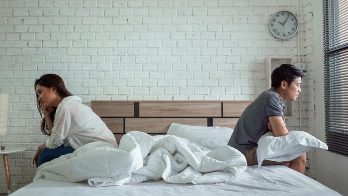 pasutri Asian couples quarrel sit in bed ,they argue not to talk to each other. They are unhappy