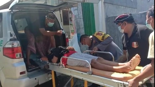 Polisi bersama pecalang di Desa Keramas, Gianyar, membantu Masuji ke rumah sakit guna mendapat penanganan medis.