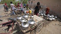Cuaca panas juga dirasakan oleh warga di kawasan Ahmedabad, India. Warga berdatangan ke sumur yang berada di kompleks sebuah kuil untuk mendapatkan air. (AP Photo/Ajit Solanki).