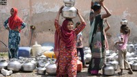 Kebutuhan akan air minum di tengah cuaca panas yang melanda Ahmedabad membuat sejumlah warga, baik orang dewasa maupun anak-anak berdatangan untuk mendapatkan air. (AP Photo/Ajit Solanki).