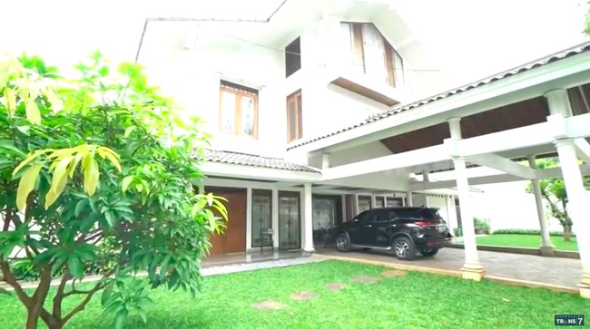 Inilah rumah aktris dan penyanyi dangdut senior Camelia Malik. Tampak depan, rumah tersebut hadir dalam arsitekur bergaya minimalis era 90-an. (Foto: YouTube/Trans7 Official)