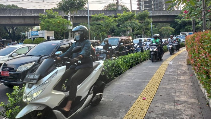 Sejumlah pemotor melintas di atas trotoar di Jl Cikini Raya, Jakarta Pusat