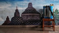 Tabung berisi cairan desinfektan di depan mural sekolah.