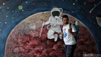 Penyemprotan di depan mural bergambar astronot di SD tersebut.