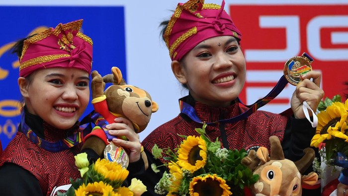 Senyum Manis Pesilat Ganda Putri Raih Emas SEA Games Vietnam Pesilat Indonesia Riska Hermawan (kiri) dan Ririn Rinasih (kanan) berpose dengan medali emasnya yang diraih pada final Seni Ganda Putri Pencak Silat SEA Games 2021 Vietnam di Bac Tu Liem Sport Center, Hanoi, Rabu (11/5/2022). Pesilat Indonesia Riska dan Ririn berhasil meraih emas setalah mengalahkan tim pesilat Vietnam . ANTARA FOTO/Zabur Karuru/foc.
