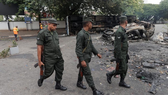 Sisa-sisa Kerusuhan Maut di Sri Lanka An air force personnel stands guard at a check point near a damaged bus of Sri Lanka's ruling party supporters after it was set on fire during a clash of pro and anti-government demonstrators near the Prime Minister's official residence, amid the country's economic crisis, in Colombo, Sri Lanka, May 10, 2022. REUTERS/Dinuka Liyanawatte