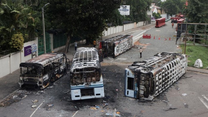 Sisa-sisa Kerusuhan Maut di Sri Lanka An air force personnel stands guard at a check point near a damaged bus of Sri Lanka's ruling party supporters after it was set on fire during a clash of pro and anti-government demonstrators near the Prime Minister's official residence, amid the country's economic crisis, in Colombo, Sri Lanka, May 10, 2022. REUTERS/Dinuka Liyanawatte