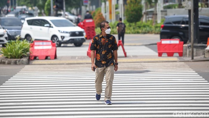 Sejumlah pekerja tengah melintas di pelican cross di kawasan Sarinah, Thamrin, Jakarta, Rabu (11/5/2022).