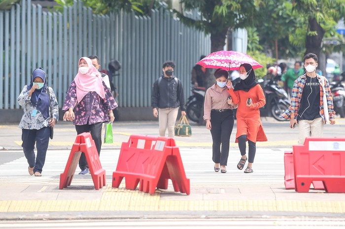 Sejumlah pekerja tengah melintas di pelican cross di kawasan Sarinah, Thamrin, Jakarta, Rabu (11/5/2022).