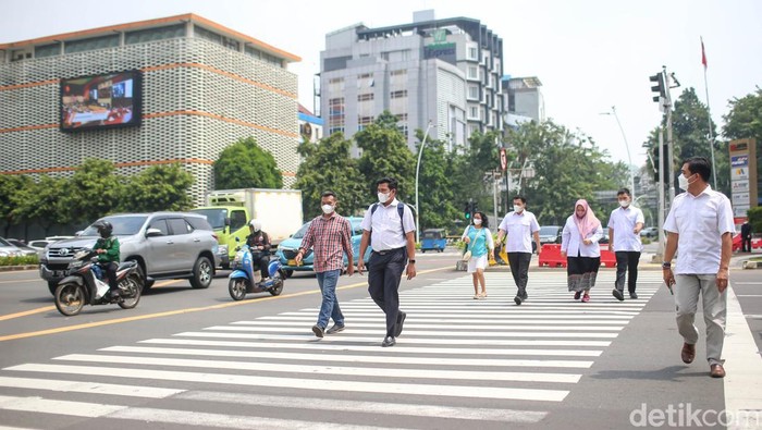 Sejumlah pekerja tengah melintas di pelican cross di kawasan Sarinah, Thamrin, Jakarta, Rabu (11/5/2022).