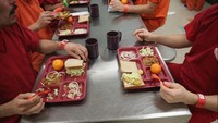 Ada roti sandwich, potongan daging, bawang bombay, dan buah jeruk yang jadi menu sehari-hari para narapidana di Adelanto Detention Facility di California. Foto: John Moore/Getty Images
