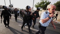 Pasukan keamanan Israel tampak menahan seorang demonstran Palestina di dekat rumah wartawan senior Al Jazeera, Shireen Abu Aqleh yang tewas ditembak saat tengah meliput operasi penyerbuan pasukan Israel di kamp pengungsi Jenin di Tepi Barat.