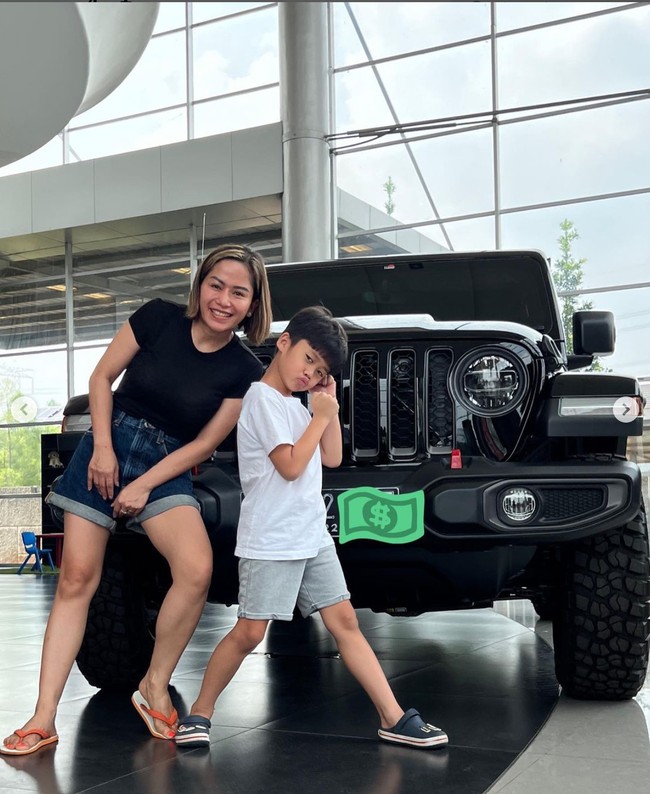 Dalam unggahan Instagramnya terlihat Farida Nurhan yang berpose di depan mobil Wrangler Rubicon berwarna hitam bersama sang anak. Farida terlihat berpenampilan simpel menggunakan kaos hitam dan celana pendek. Penampilannya itu dilengkapi dengan sandal jepit berwarna oranye. Foto: Instagram/@farida.nurhan