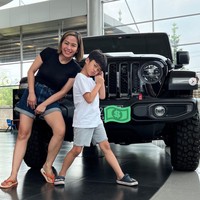 Dalam unggahan Instagramnya terlihat Farida Nurhan yang berpose di depan mobil Wrangler Rubicon berwarna hitam bersama sang anak. Farida terlihat berpenampilan simpel menggunakan kaos hitam dan celana pendek. Penampilannya itu dilengkapi dengan sandal jepit berwarna oranye. Foto: Instagram/@farida.nurhan