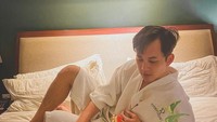 Momen makan di hotelnya terlihat pada foto ini. Ia berpose dengan nampan yang berisikan makanan yang disajikan di atas kasur. Foto: Instagram @kikifarrel