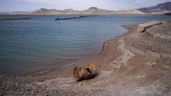 A formerly sunken boat sits on cracked earth hundreds of feet from what is now the shoreline on Lake Mead at the Lake Mead National Recreation Area, Monday, May 9, 2022, near Boulder City, Nev. Lake Mead is receding and Sin City is awash with mob lore after a second set of human remains emerged within a week from the depths of the drought-stricken Colorado River reservoir just a short drive from the Las Vegas Strip.  (AP Photo/John Locher)