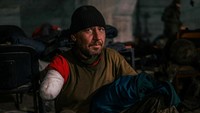 Seorang anggota layanan Ukraina duduk di dalam rumah sakit lapangan di dalam bunker pabrik baja. Luka yang cukup serius membuat tangannya terpaksa diamputasi.