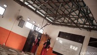 Beberapa murid mengambil modul pembelajaran di lemari ruangan kelas yang ambruk.