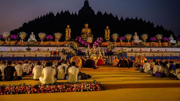 MAGELANG, CENTRAL JAVA, INDONESIA - MAY 18: Buddhist followers pray at Borobudur temple during celebrations for Vesak Day on May 18, 2019 in Magelang, Central Java, Indonesia. Buddhists in Indonesia celebrate Vesak at the Borobudur temple annually, which makes it the most visited tourist attraction in Indonesia. It is observed during the full moon in May or June, with the ceremony centered at three Buddhist temples by walking from Mendut to Pawon and ending at Borobudur. The stages of life of Buddhism's founder, Gautama Buddha, which are celebrated at Vesak are his birth, enlightenment to Nirvana, and his passing (Parinirvana). (Photo by Ulet Ifansasti/Getty Images)