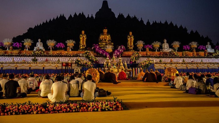 MAGELANG, CENTRAL JAVA, INDONESIA - MAY 18: Buddhist followers pray at Borobudur temple during celebrations for Vesak Day on May 18, 2019 in Magelang, Central Java, Indonesia. Buddhists in Indonesia celebrate Vesak at the Borobudur temple annually, which makes it the most visited tourist attraction in Indonesia. It is observed during the full moon in May or June, with the ceremony centered at three Buddhist temples by walking from Mendut to Pawon and ending at Borobudur. The stages of life of Buddhisms founder, Gautama Buddha, which are celebrated at Vesak are his birth, enlightenment to Nirvana, and his passing (Parinirvana). (Photo by Ulet Ifansasti/Getty Images)