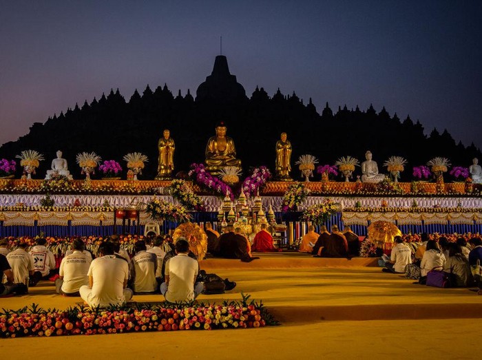 MAGELANG, CENTRAL JAVA, INDONESIA - MAY 18: Buddhist followers pray at Borobudur temple during celebrations for Vesak Day on May 18, 2019 in Magelang, Central Java, Indonesia. Buddhists in Indonesia celebrate Vesak at the Borobudur temple annually, which makes it the most visited tourist attraction in Indonesia. It is observed during the full moon in May or June, with the ceremony centered at three Buddhist temples by walking from Mendut to Pawon and ending at Borobudur. The stages of life of Buddhisms founder, Gautama Buddha, which are celebrated at Vesak are his birth, enlightenment to Nirvana, and his passing (Parinirvana). (Photo by Ulet Ifansasti/Getty Images)