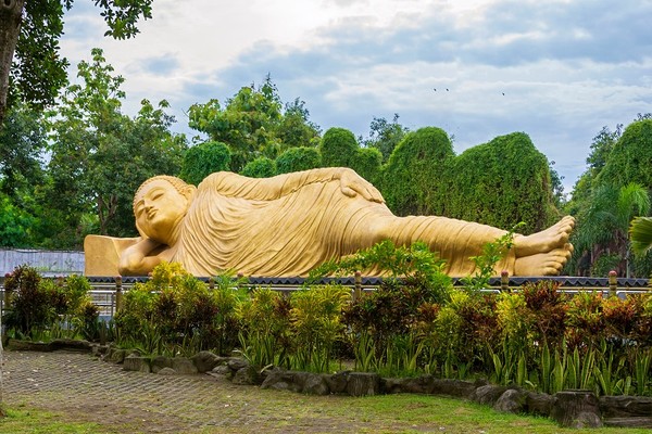 Maha Vihara Mojopahit dikenal sebagai wihara yang memiliki patung Buddha yang sedang berbaring ketiga terbesar di Asia. Wihara ini berlokasi di Desa Bejijong, Kecamatan Trowulan, Kabupaten Mojokerto, Provinsi Jawa Timur.  (dok Pegipegi)