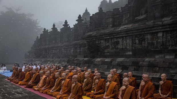 MAGELANG, CENTRAL JAVA, INDONESIA - MAY 18: Buddhist monks pray at Borobudur temple during celebrations for Vesak Day on May 18, 2019 in Magelang, Central Java, Indonesia. Buddhists in Indonesia celebrate Vesak at the Borobudur temple annually, which makes it the most visited tourist attraction in Indonesia. It is observed during the full moon in May or June, with the ceremony centered at three Buddhist temples by walking from Mendut to Pawon and ending at Borobudur. The stages of life of Buddhism's founder, Gautama Buddha, which are celebrated at Vesak are his birth, enlightenment to Nirvana, and his passing (Parinirvana). (Photo by Ulet Ifansasti/Getty Images)