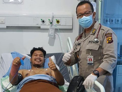 AKP Silaen tersenyum meski masih terbaring di tempat tidur rumah sakit.