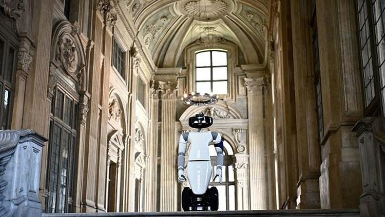 Canggih! Robot 5G Jadi Pemandu Museum di Italia A photo shows the humanoid robot R1, designed by the Italian Institute of Technology, serving as a virtual guide for visitors, holding a guided tour for tourists in the ceramic room at the Palazzo Madama museum in Turin on May 12, 2021. - The experimentation is part of the European Union funded project 5G-TOURS that aims to test and use 5G technologies to provide useful, efficient and reliable services to citizens and tourists. The robot is able to describe the works and answer questions relating to the author or the historical period to which they belong. - RESTRICTED TO EDITORIAL USE - MANDATORY MENTION OF THE ARTIST UPON PUBLICATION - TO ILLUSTRATE THE EVENT AS SPECIFIED IN THE CAPTION (Photo by MARCO BERTORELLO / AFP) / RESTRICTED TO EDITORIAL USE - MANDATORY MENTION OF THE ARTIST UPON PUBLICATION - TO ILLUSTRATE THE EVENT AS SPECIFIED IN THE CAPTION / RESTRICTED TO EDITORIAL USE - MANDATORY MENTION OF THE ARTIST UPON PUBLICATION - TO ILLUSTRATE THE EVENT AS SPECIFIED IN THE CAPTION (Photo by MARCO BERTORELLO/AFP via Getty Images)