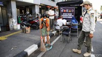 Petugas Satpol PP melakukan razia masker di depan Pasar Jatinegara Jakarta, Jumat (13/5/2022).