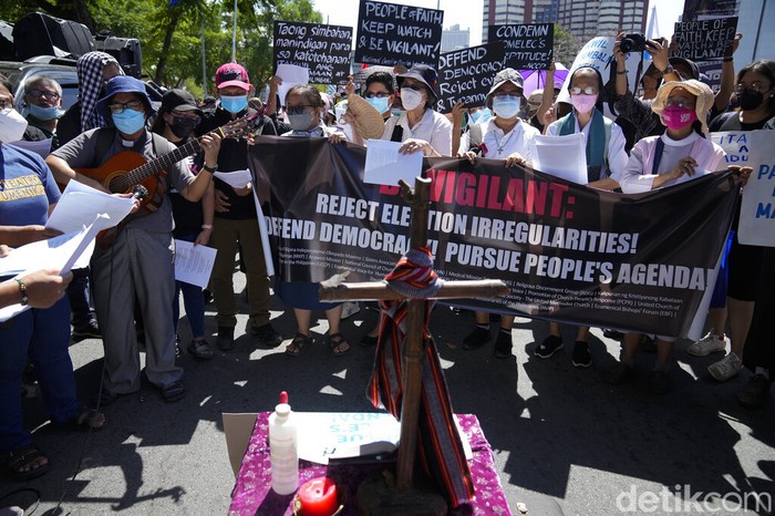 A Catholic nun clenches her fist as she joins protesters against presidential frontrunner Ferdinand 