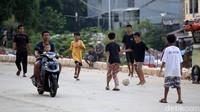Meski berbahaya, mereka tampak tetap asyik menikmati bermain di lahan Minim di sisi jalanan arteri yang cukup ramai dilalui kendaraan hilir mudik.