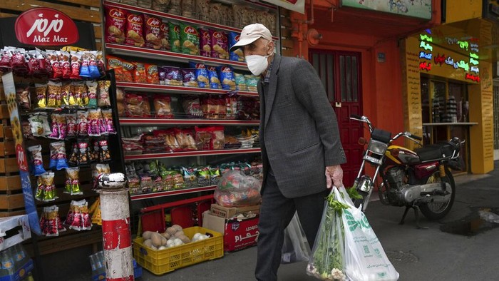 Warga Iran Panik, Harga Bahan Pokok Naik Drastis An elderly man carries his shopping in front of a grocery store in Tehran, Iran, Wednesday, May 11, 2022. Iran abruptly raised prices as much as 300% for a variety of staples such as cooking oil, chicken, eggs and milk on Thursday. (AP Photo/Vahid Salemi)