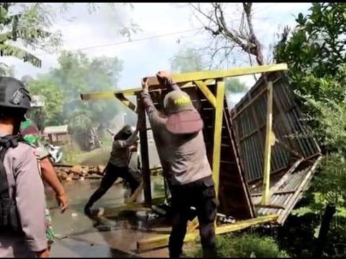 Aparat kepolisian dan TNI saat membuka akses jalan yang diblokir selama 4 hari di Bima