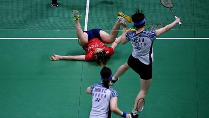 Chinas Chen Qingchen (top) falls next to teammate Jia Yifan as she returns a shot against South Koreas Lee So-hee and Shin Seung-chan in their doubles match during the womens finals of the Thomas and Uber Cup badminton tournament in Bangkok on May 14, 2022. (Photo by Manan VATSYAYANA / AFP)