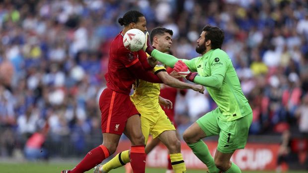 Liverpool's goalkeeper Alisson taps the ball away from Chelsea's Christian Pulisic, center, and Liverpool's Virgil van Dijk during the English FA Cup final soccer match between Chelsea and Liverpool, at Wembley stadium, in London, Saturday, May 14, 2022. (AP Photo/Ian Walton)
