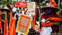 Massa buruh membawa sejumlah atribut demo, di antaranya spanduk dan banner bertuliskan tuntutan.