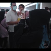 Ternyata Nissa Sabyan dan rekannya sudah menyiapkan kejutan untuk warga RW 01 Jaticempaka. Dia sengaja berjalan dari belakang panggung memakai hoodie hitam untuk merahasiakan identitasnya. Meskipun banyak yang berlalu-lalang, penyamarannya berhasil hingga naik ke atas panggung. Foto: dok. YouTube SABYAN