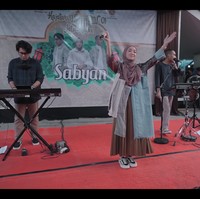 Penampilan Nissa Sabyan di acara hajatan itu pun terbilang unik. Nissa memakai gamis bercorak merah yang dipermak ulang. Ada tambalan yang menyerupai celana jeans pada bagian kanan depan, lengkap dengan sakunya. Foto: dok. YouTube SABYAN